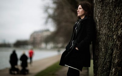 Kvinde står op ad et træ