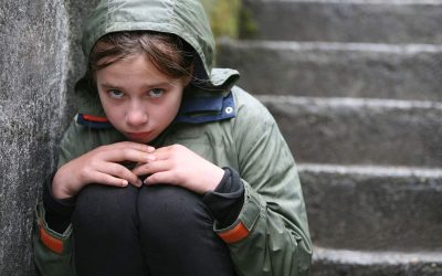 Dreng med hætte på kigger ud i luften