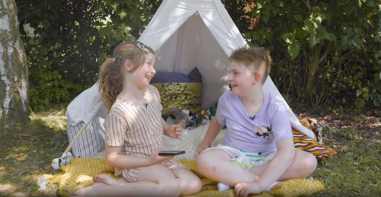 Saga og Georg sidder foran et telt