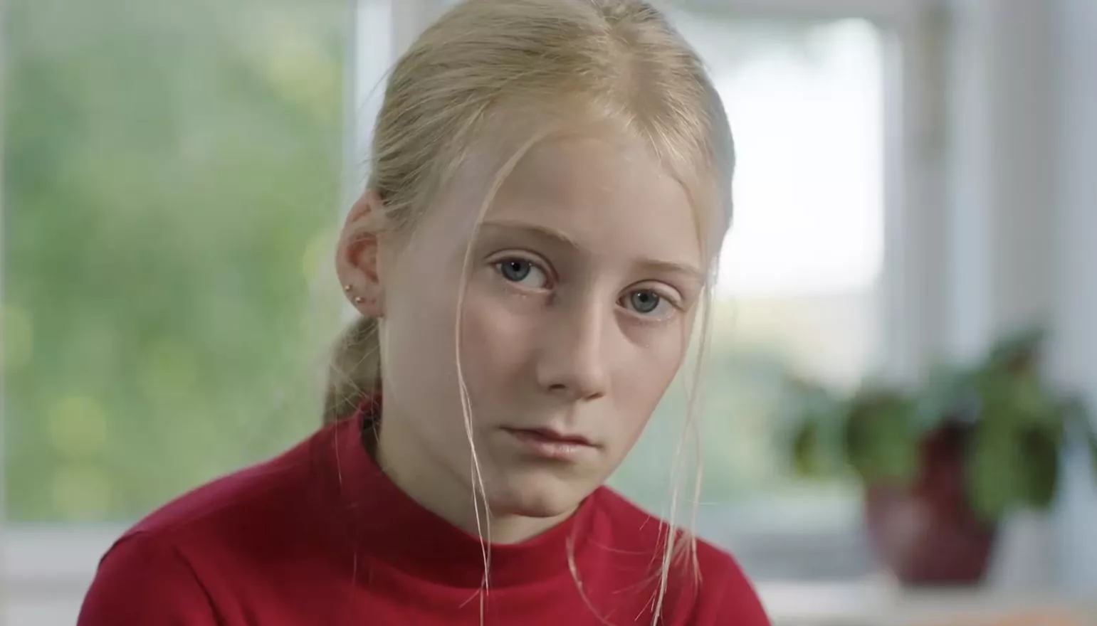 Lyshåret pige kigger ind i kameraet