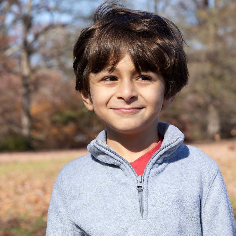 Mørkhåret dreng står udenfor