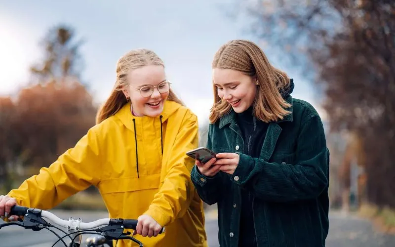 To piger kigger på en telefon