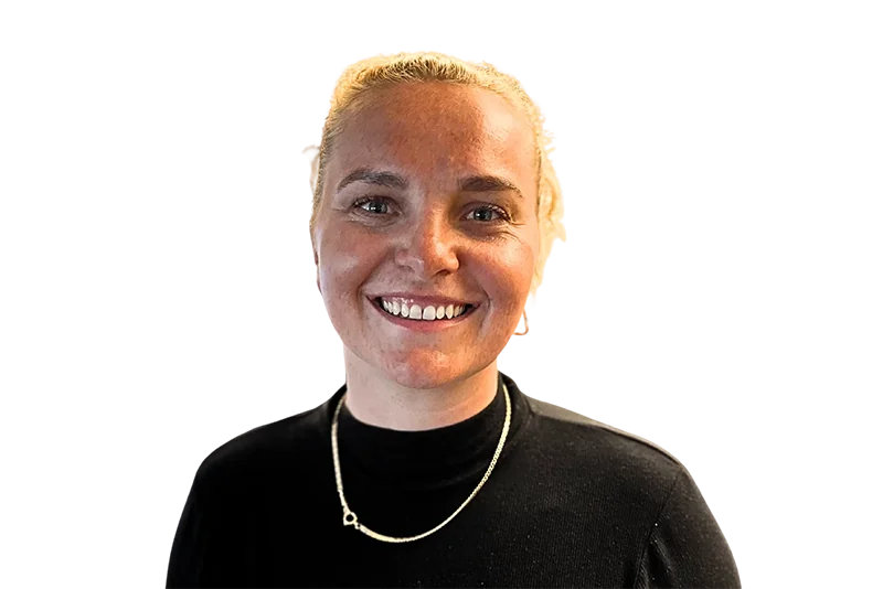 Blond kvinde smiler og kigger ind i kameraet