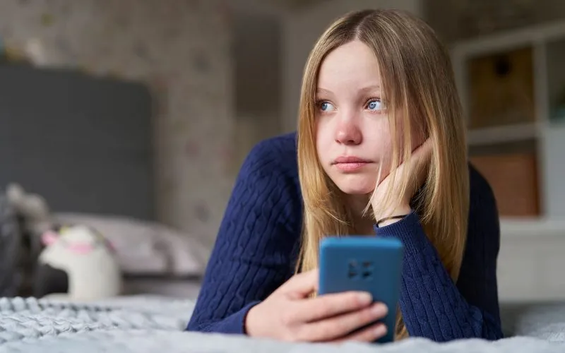 Trist pige kigger ud ad vinduet