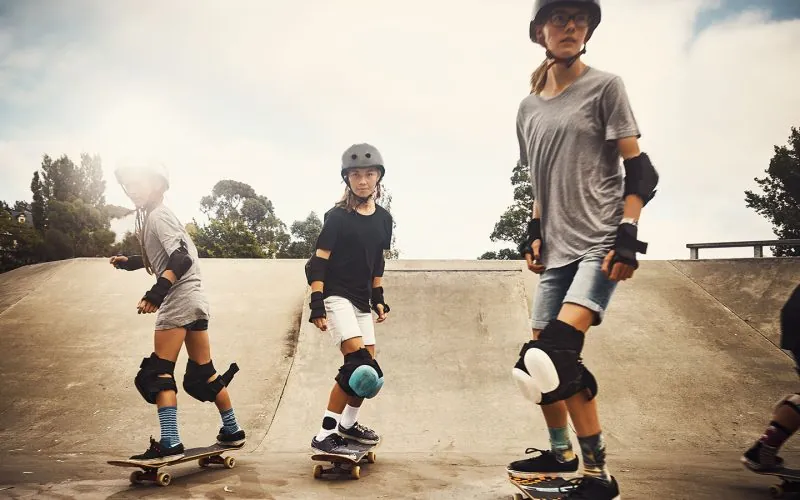 Tre piger, der står på skateboard sammen