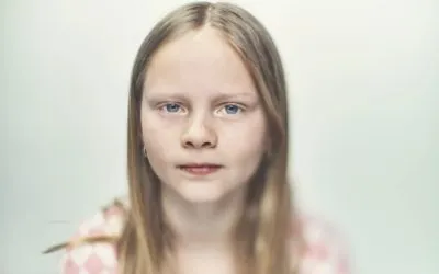 Pige på hvid baggrund kigger ind i kameraet